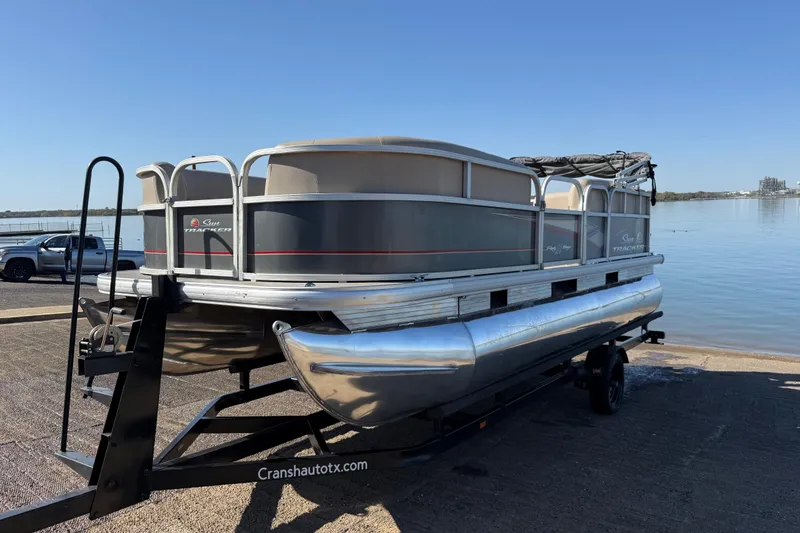 Slide: The Image of 2018 Sun Tracker Party Barge 18 DLX interior with seating on a calm lake. - 59