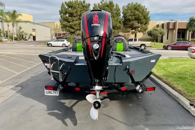 Slide: The Image of 2023 Ranger RT198P boat with powerful outboard motor in a parking lot. - 2