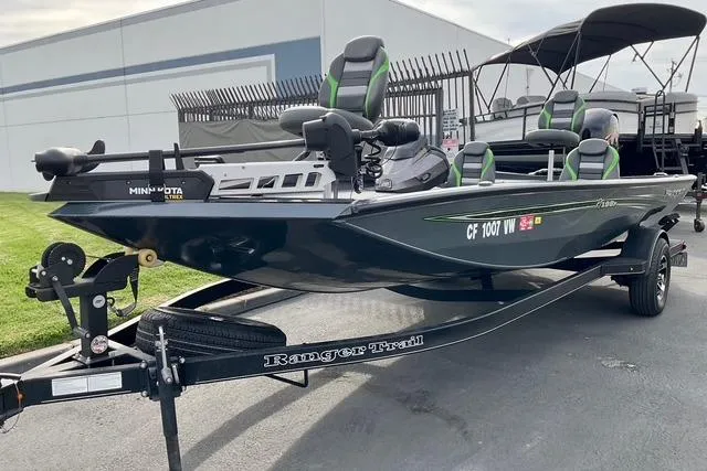 Slide: The Image of 2023 Ranger RT198P fishing boat on trailer, parked outdoors near a building. - 3