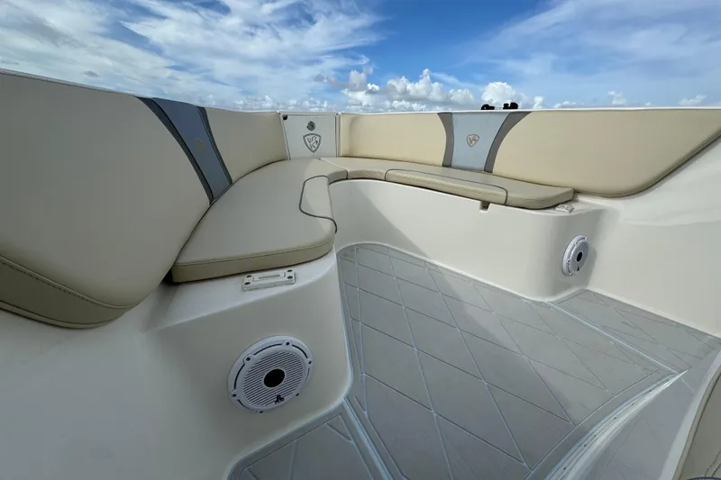 Slide: The Image of 2015 Century 2600 CC boat interior with beige seating and speakers under a blue sky. - 20