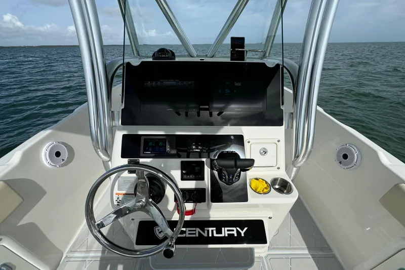 Slide: The Image of Century 2600 CC 2015 boat dashboard with steering wheel and controls on open water. - 32