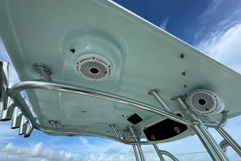 Slide: The Image of T-top of 2015 Century 2600 CC boat with speakers and rod holders against blue sky. - 51