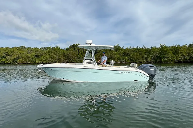 Slide: The Image of 2015 Century 2600 CC boat on calm water with lush greenery background. - 7