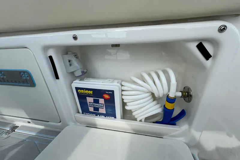 Slide: The Image of Storage compartment on a 2015 Century 2600 CC boat with hose and first aid kit. - 72