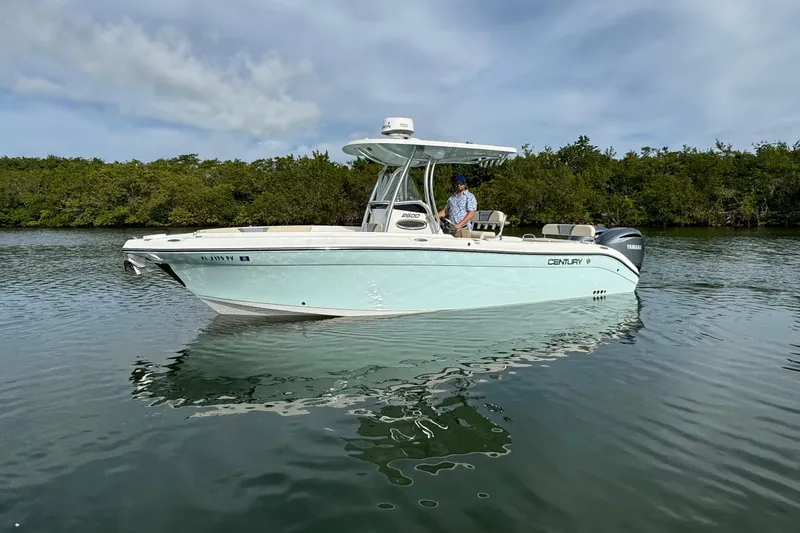 Slide: The Image of 2015 Century 2600 CC boat on calm water with lush greenery background. - 8