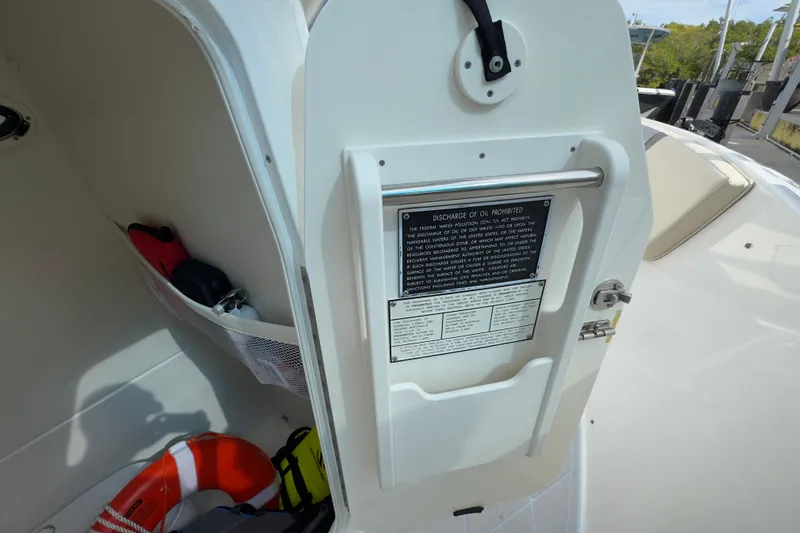 Slide: The Image of 2015 Century 2600 CC boat interior with safety equipment and oil discharge warning. - 84