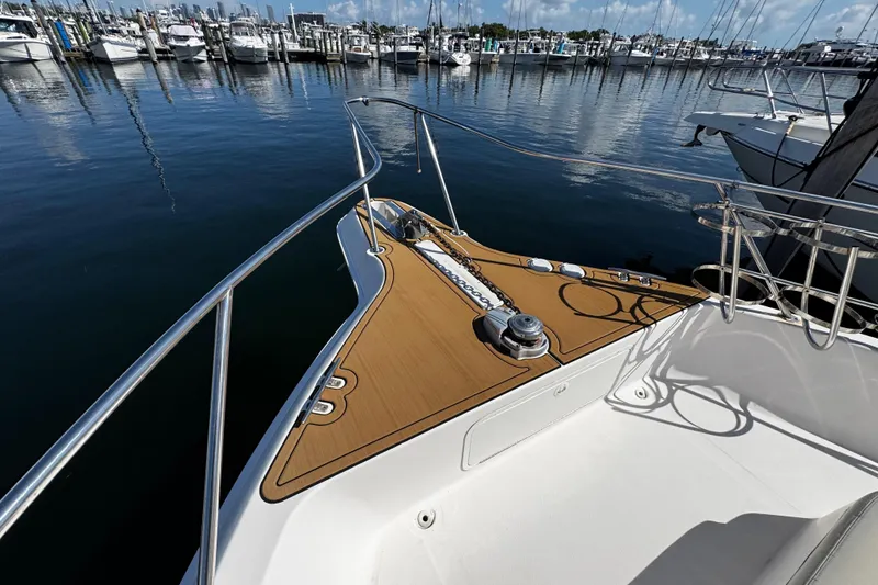 Slide: The Image of 1999 Sea Ray 440 Express Bridge yacht docked at marina, showcasing bow and railing. - 12