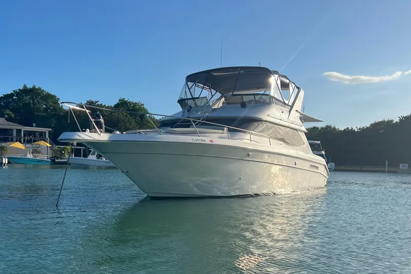 Slide: The Image of 1999 Sea Ray 440 Express Bridge yacht anchored in serene waters. - 3