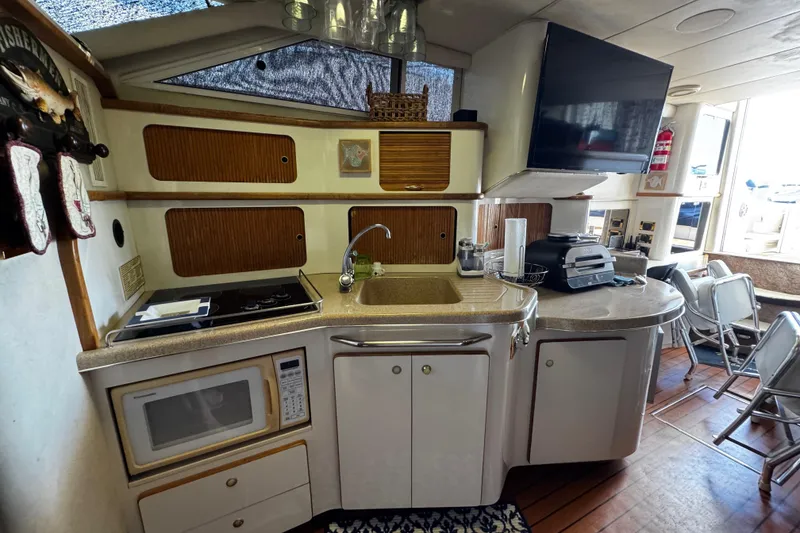 Slide: The Image of 1999 Sea Ray 440 Express Bridge kitchen with microwave, sink, and appliances. - 39