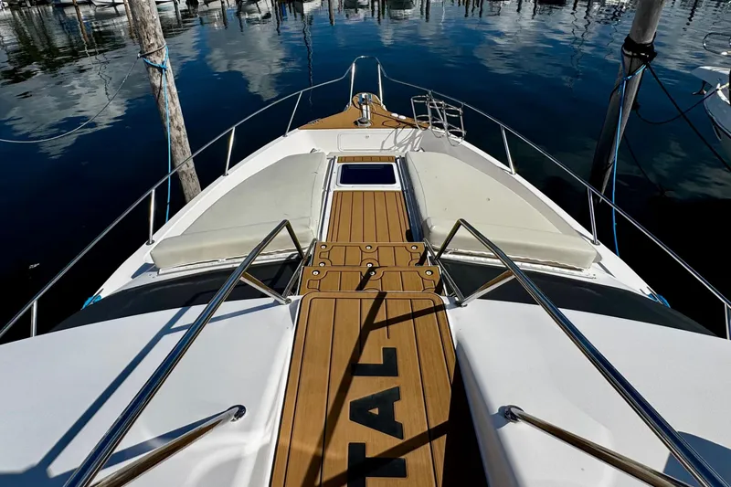 Slide: The Image of 1999 Sea Ray 440 Express Bridge yacht with teak deck, docked in a marina. - 9