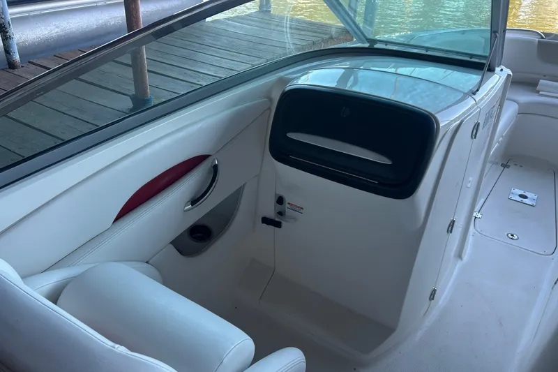 Slide: The Image of 2008 Chaparral 276 SSX boat interior with white seating and storage compartment. - 10