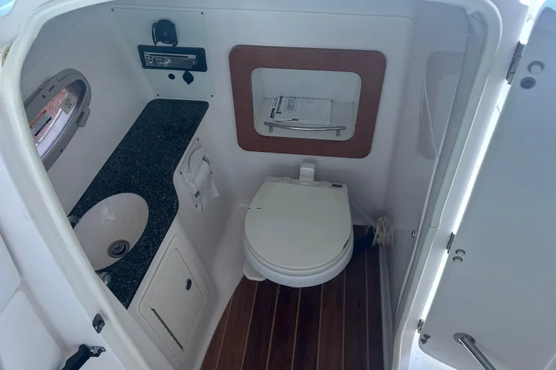 Slide: The Image of 2008 Chaparral 276 SSX boat bathroom with sink, toilet, and wood flooring. - 15