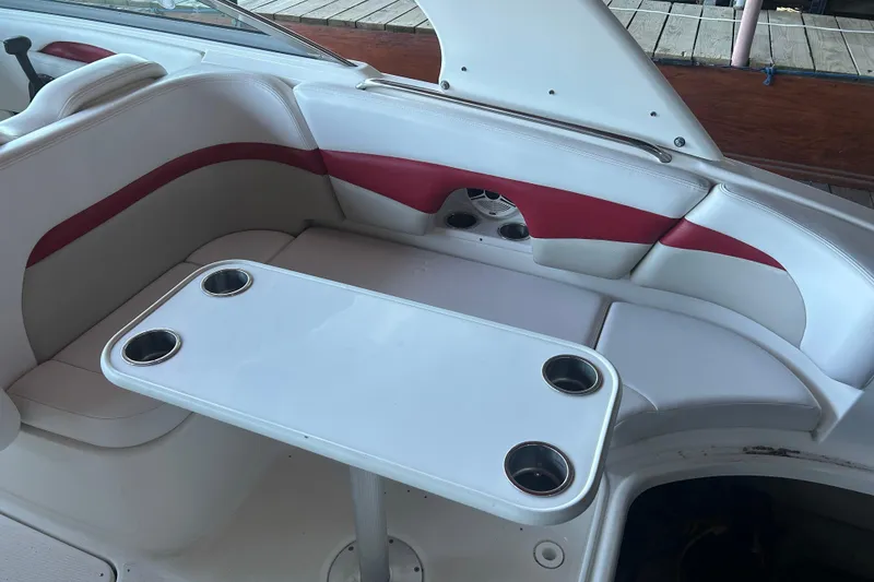 Slide: The Image of 2008 Chaparral 276 SSX boat interior with white and red seating, table, and cup holders. - 7