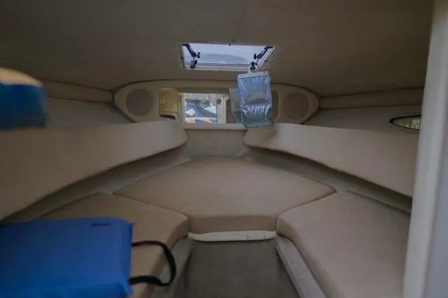 Slide: The Image of Interior cabin of 2007 Sea Ray 215 Weekender boat, featuring beige upholstery and a skylight. - 7