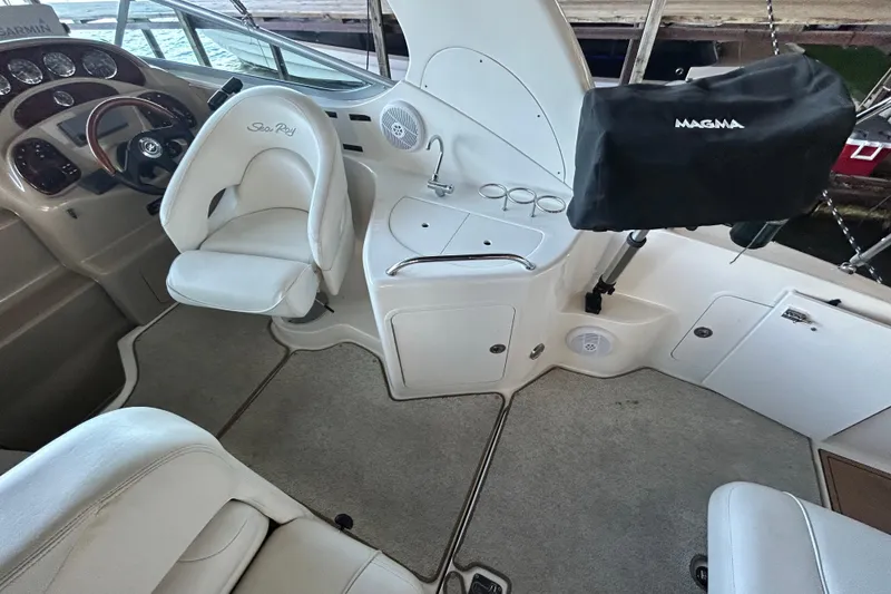 Slide: The Image of 2005 Sea Ray 280 Sundancer cockpit with helm, seating, and covered grill. - 10