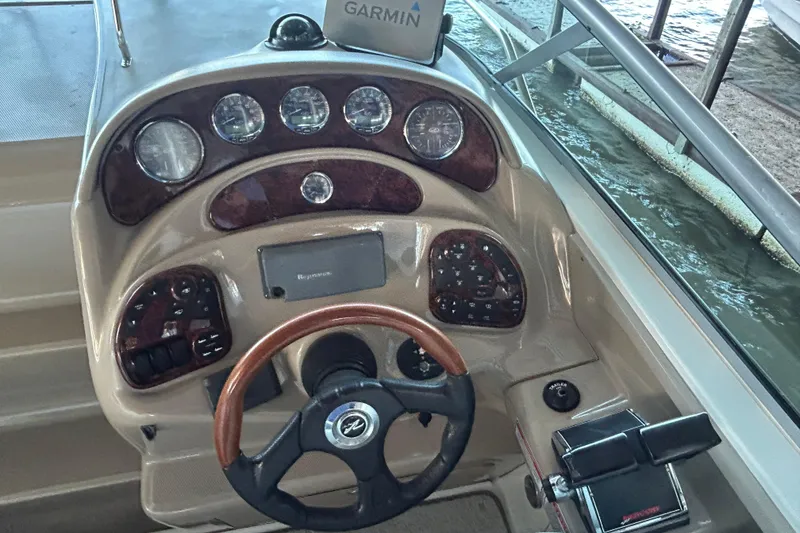 Slide: The Image of 2005 Sea Ray 280 Sundancer helm with Garmin navigation and wood-accented dashboard. - 13