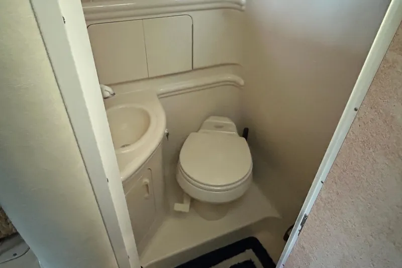 Slide: The Image of Compact bathroom in 2005 Sea Ray 280 Sundancer boat, featuring toilet and sink. - 14