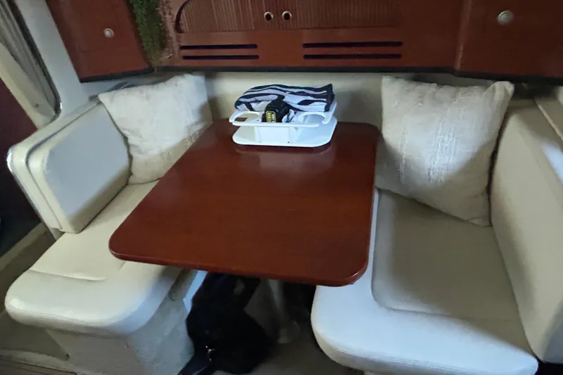 Slide: The Image of Interior of 2005 Sea Ray 280 Sundancer with cozy dining area and wooden table. - 17