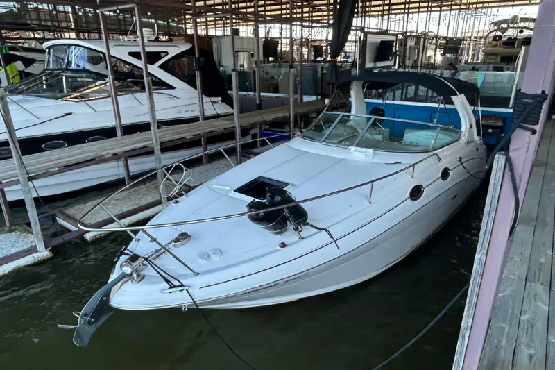 Slide: The Image of 2005 Sea Ray 280 Sundancer docked in a marina, featuring sleek white design. - 2