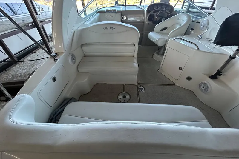 Slide: The Image of 2005 Sea Ray 280 Sundancer boat interior with white seating and control panel. - 6
