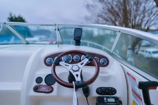 Slide: The Image of 2007 Sea Ray 215 Weekender boat dashboard with steering wheel and controls. - 12