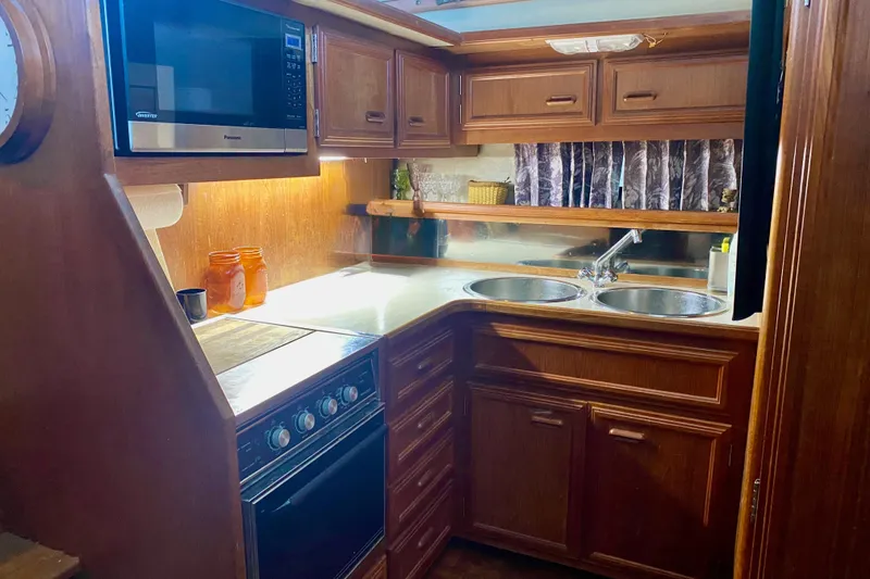 Slide: The Image of 1989 Carver 38 Aft Cabin Motor Yacht kitchen with wood cabinetry and modern appliances. - 16