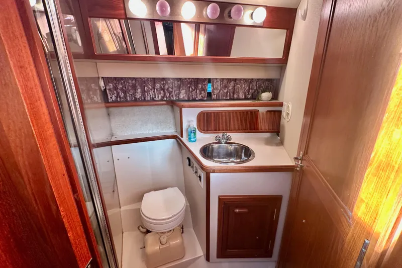 Slide: The Image of 1989 Carver 38 Aft Cabin Motor Yacht bathroom with sink, toilet, and wooden cabinetry. - 20