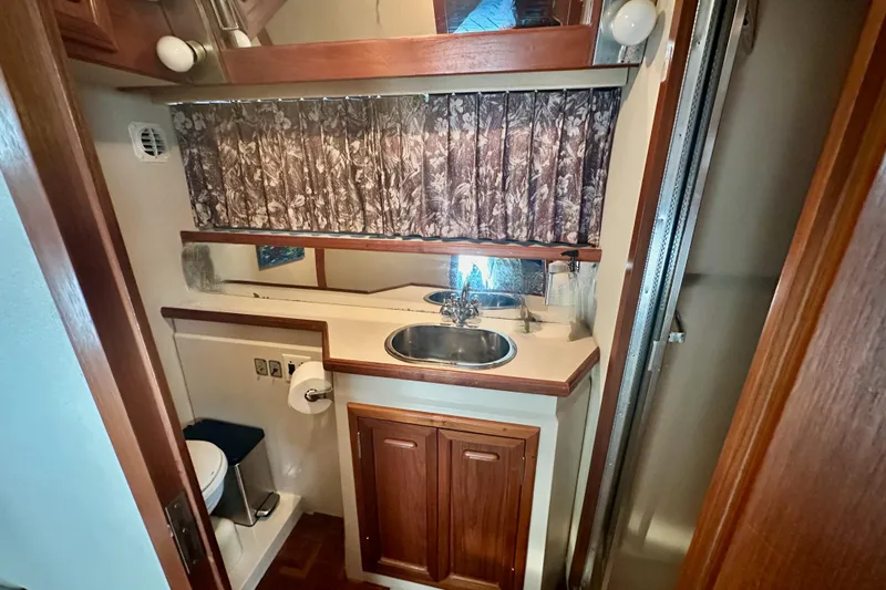 Slide: The Image of 1989 Carver 38 Aft Cabin Motor Yacht bathroom with sink, mirror, and shower. - 22