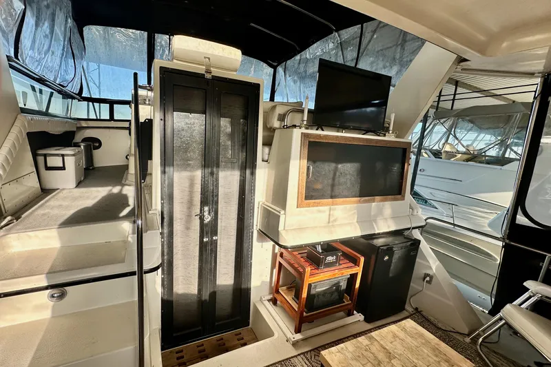 Slide: The Image of 1989 Carver 38 Aft Cabin Motor Yacht interior with seating, TV, and storage. - 9