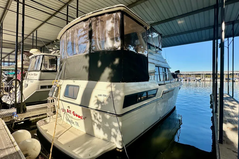 The Image of 1989 Carver 38 Aft Cabin Motor Yacht docked in marina under covered shelter. - 1