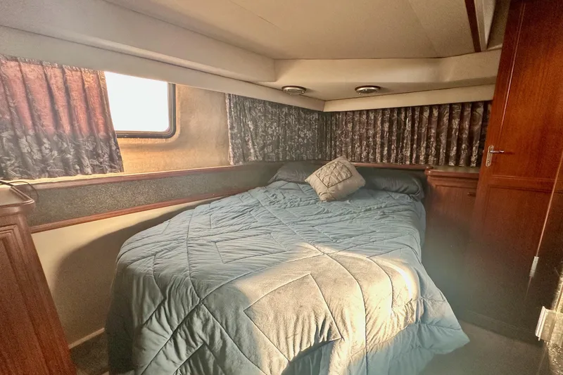Slide: The Image of Cozy bedroom in 1989 Carver 38 Aft Cabin Motor Yacht with blue bedding and wood accents. - 23