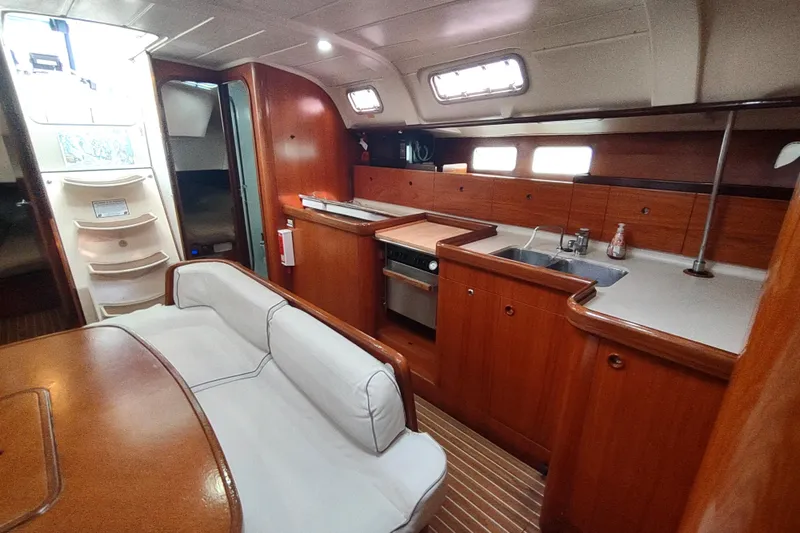 Slide: The Image of Interior of 1993 Beneteau Moorings 445 yacht with cozy seating and wooden finishes. - 24