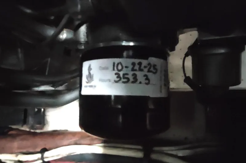 Slide: The Image of Engine compartment of 1993 Beneteau Moorings 445 with labeled filter showing date and hours. - 53