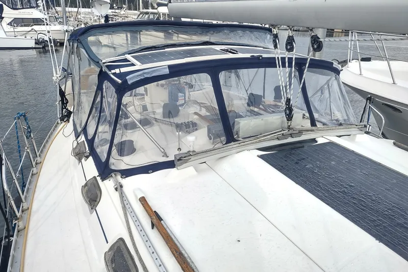Slide: The Image of 1993 Beneteau Moorings 445 sailboat with cockpit enclosure and solar panels in marina. - 9