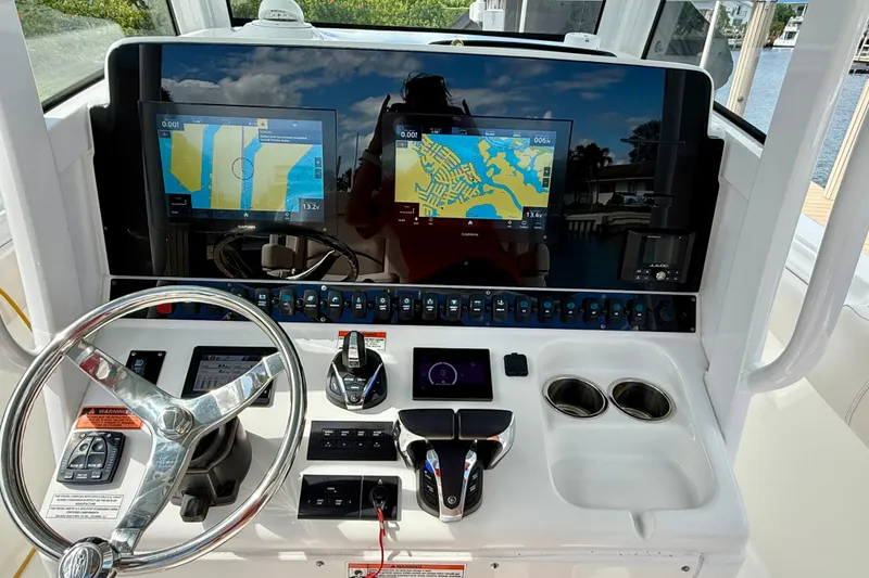 Slide: The Image of 2021 Sea Hunt Gamefish 30 boat interior with forward seating, docked near waterfront homes. - 11