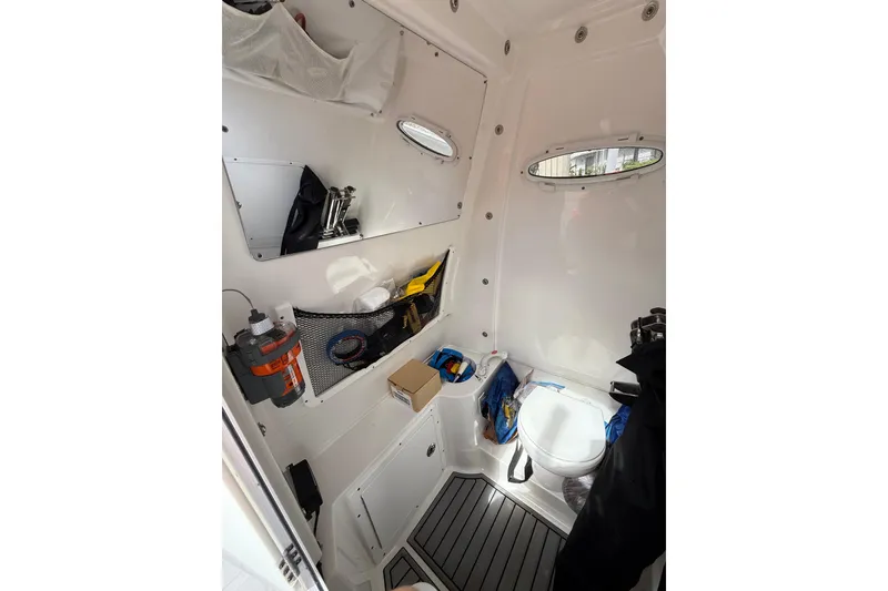 Slide: The Image of 2021 Sea Hunt Gamefish 30 Forward Seating with open storage compartments on a sunny day. - 24