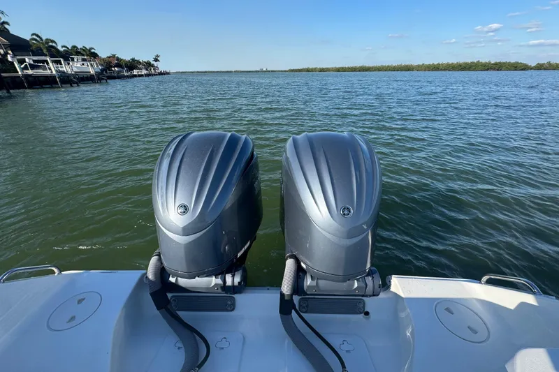 Slide: The Image of 2021 Sea Hunt Gamefish 30 boat with dual outboard motors on a calm lake. - 31