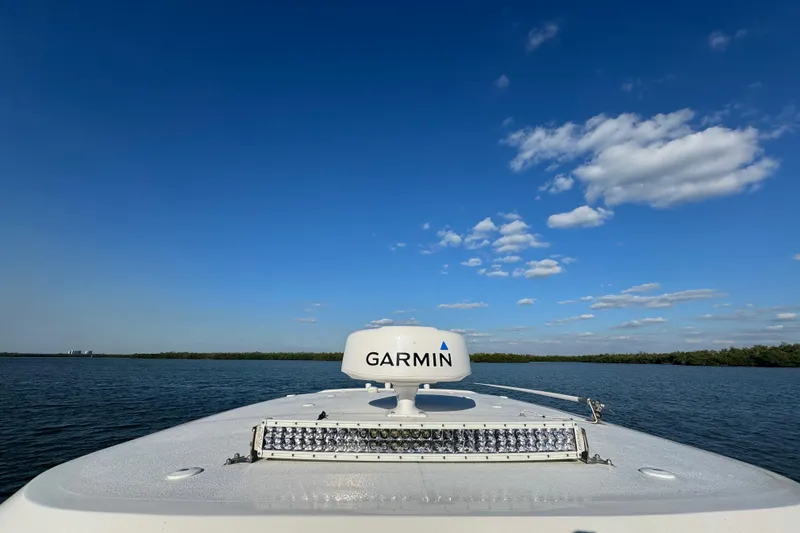 Slide: The Image of 2021 Sea Hunt Gamefish 30 boat with Garmin equipment on calm water under blue sky. - 32