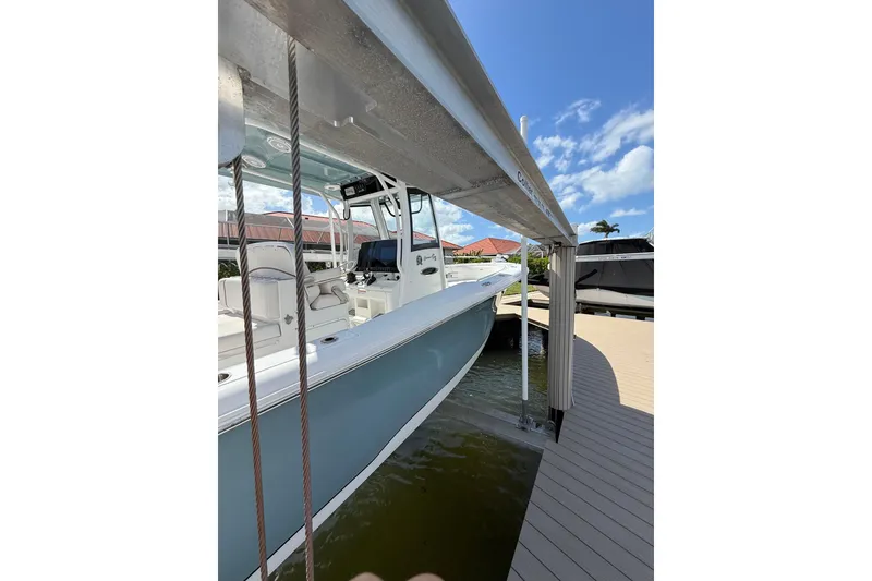 Slide: The Image of 2021 Sea Hunt Gamefish 30 boat on calm water, featuring forward seating. - 4