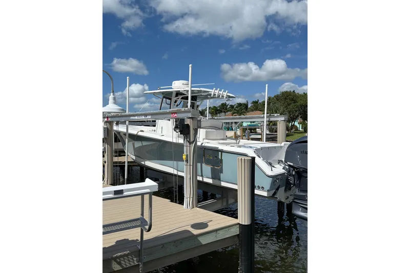 Slide: The Image of 2021 Sea Hunt Gamefish 30 boat on calm water, featuring forward seating. - 5