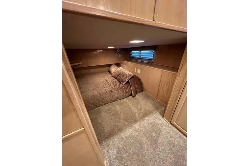 Slide: The Image of Cozy bedroom interior of 1995 Sumerset 19.5 x 95 houseboat with wood paneling and soft lighting. - 16