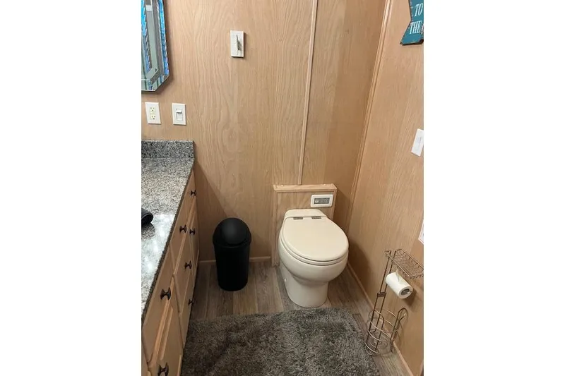 Slide: The Image of Bathroom interior of 1995 Sumerset 19.5 x 95 houseboat with wood paneling and granite countertop. - 20