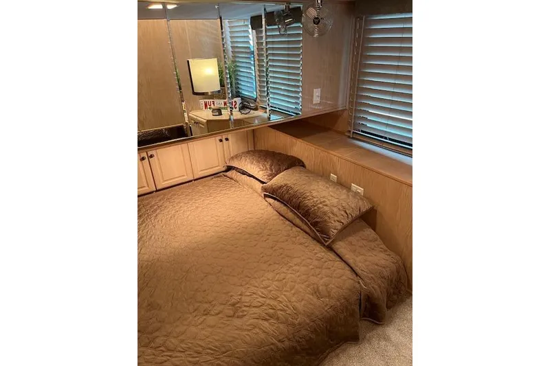 Slide: The Image of Cozy bedroom in 1995 Sumerset houseboat with brown bedding and mirrored cabinets. - 25