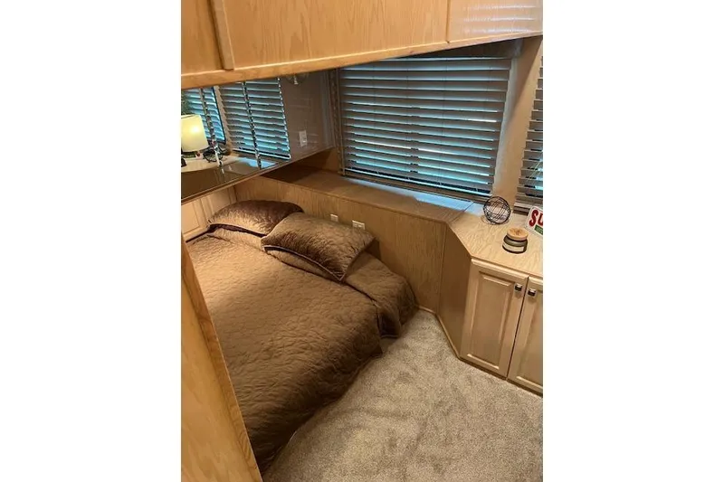 Slide: The Image of Cozy bedroom interior in a 1995 Sumerset 19.5 x 95 houseboat with wood paneling. - 26