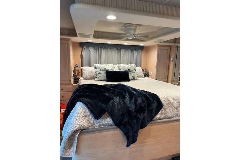 Slide: The Image of Luxurious bedroom interior in a 1995 Sumerset 19.5 x 95 houseboat, featuring elegant bedding. - 27
