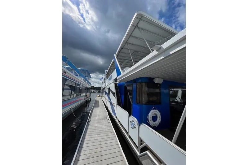 Slide: The Image of 1995 Sumerset 19.5 x 95 houseboat docked under cloudy skies. - 3