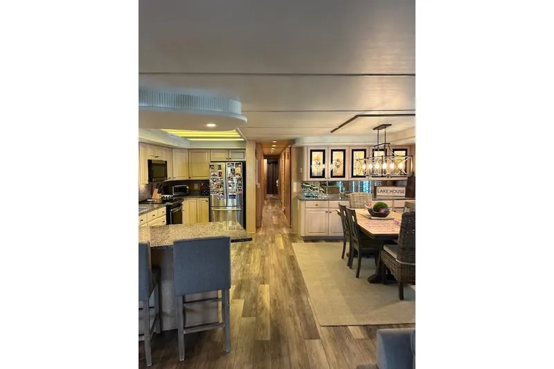 Slide: The Image of Interior of 1995 Sumerset houseboat, featuring modern kitchen and dining area with wood flooring. - 6