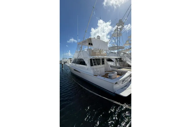 The Image of 1999 Viking 50 Convertible yacht docked under a clear blue sky. - 1