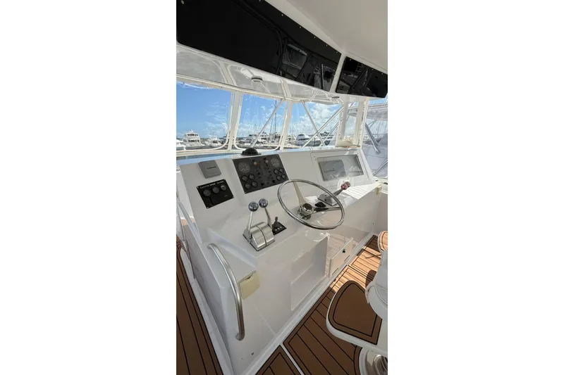 Slide: The Image of 1999 Viking 50 Convertible yacht helm with steering wheel and control panel. - 17