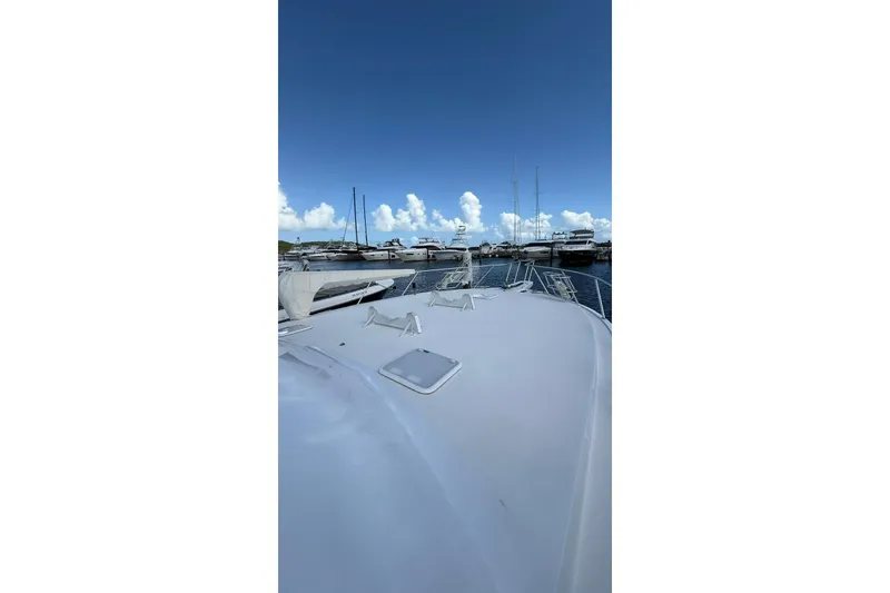 Slide: The Image of 1999 Viking 50 Convertible yacht docked at marina under clear blue sky. - 18
